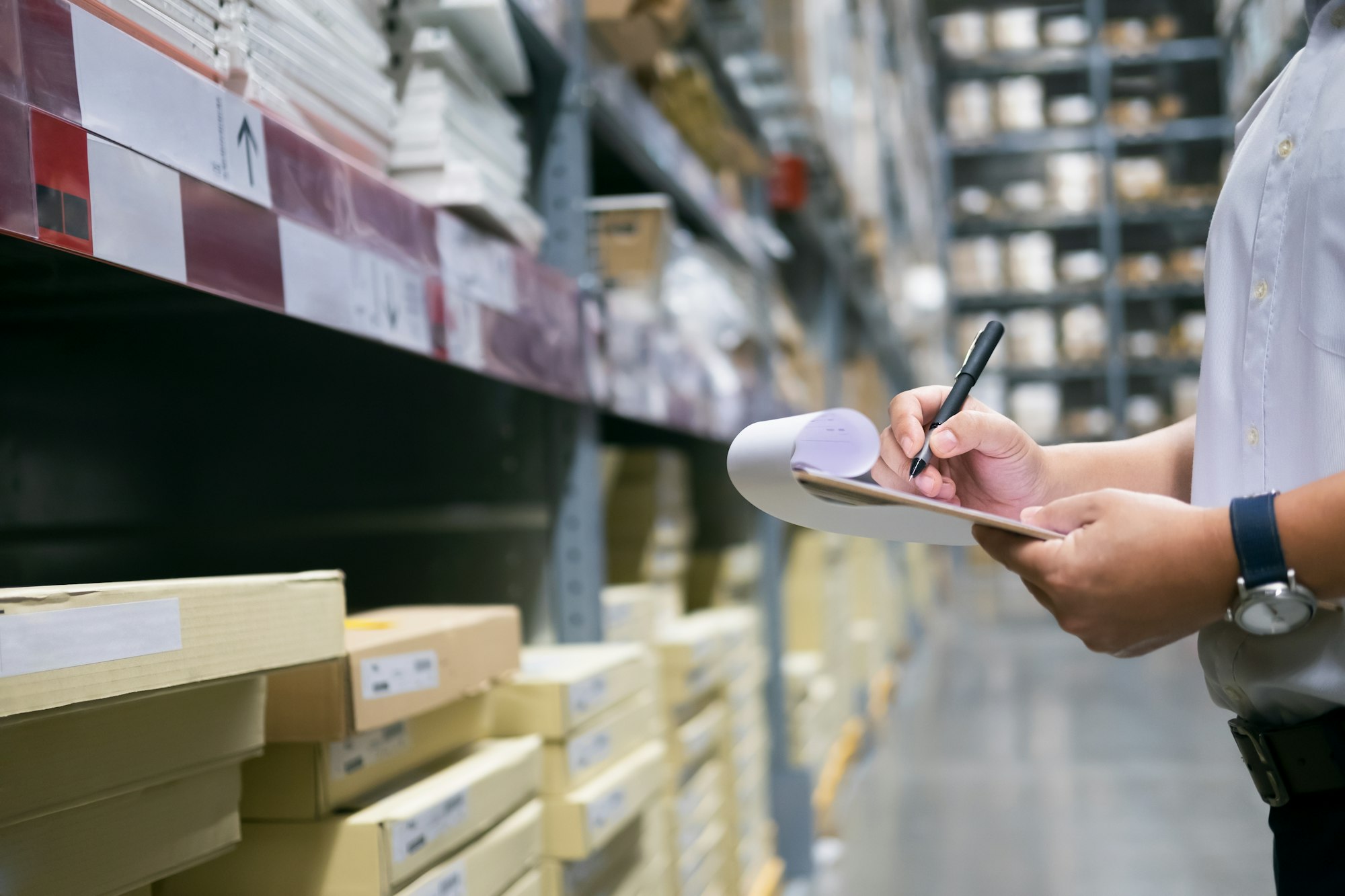 Man warehouse worker checking goods at warehouse.