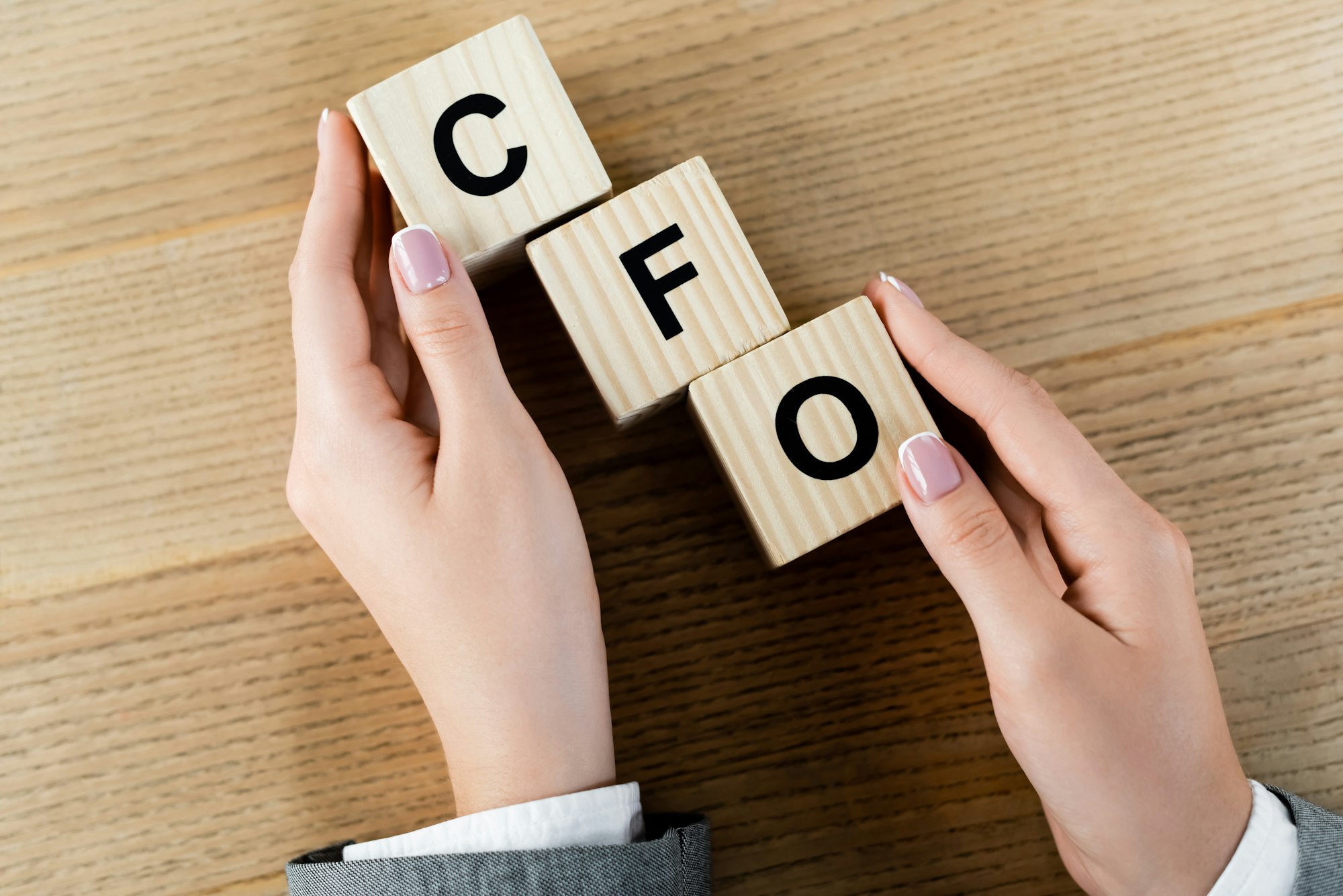 top view of businesswoman holding wooden cubes with cfo letters